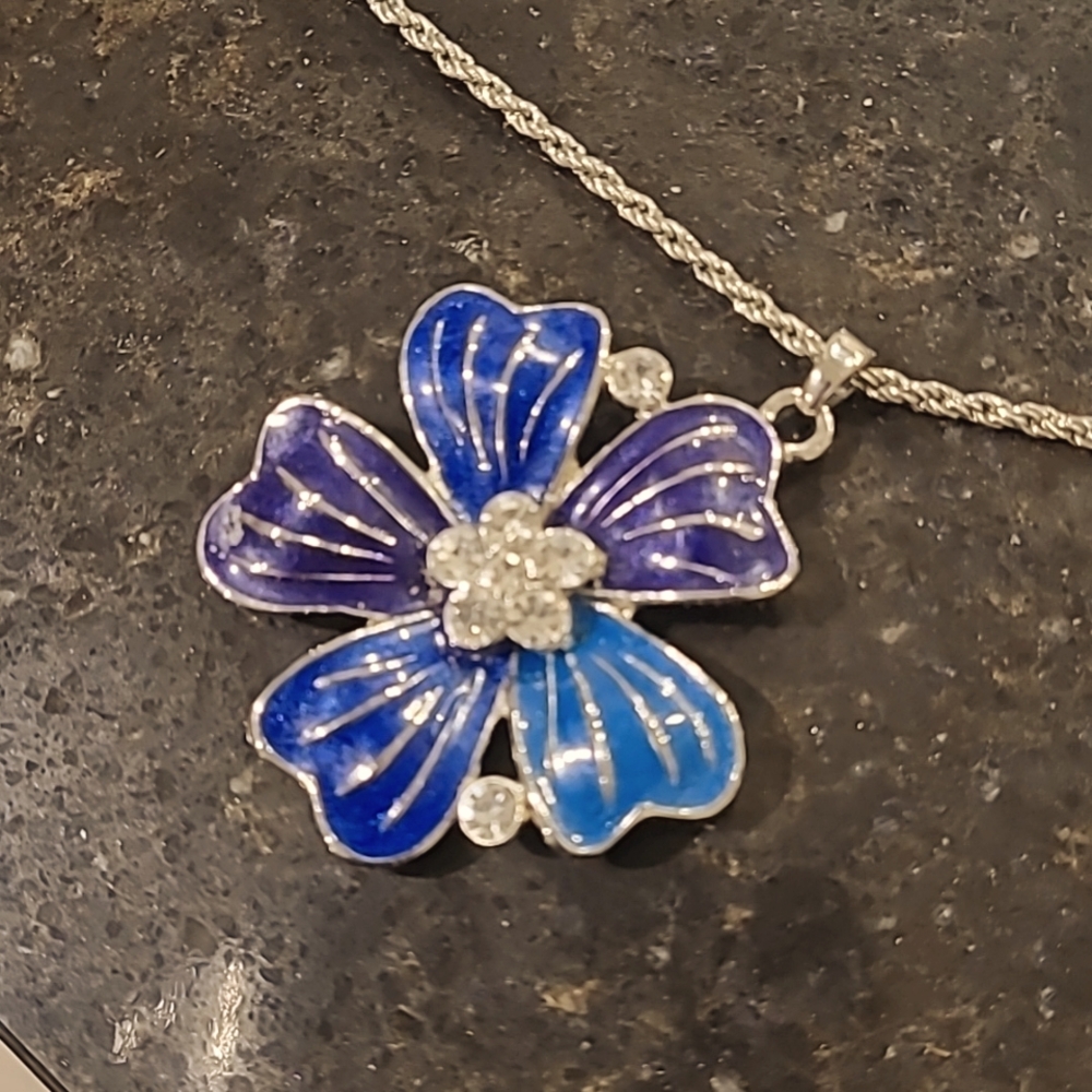 Silver and blue necklace with rhinestone details at the centre of the flower.